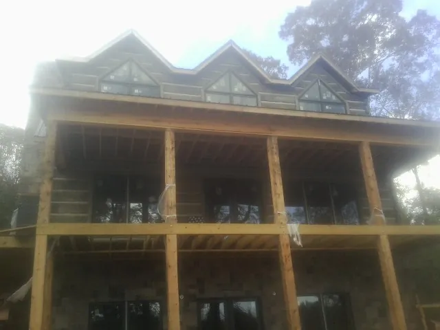 Dormers and porch framing on a large log home under construction — Roof Coating work by our crew in Snohomish